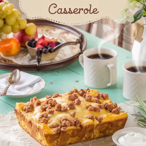 A cozy, old-fashioned kitchen scene with a rustic wooden table in the center. There's a golden-brown breakfast casserole with melted cheese and browned sausage crumbles on the table. The casserole has a fluffy cornbread base. There's a vintage breakfast tray nearby with fresh fruit, two steaming coffee mugs, and a small bowl of sour cream. The setting is bathed in warm morning light. The design is simple and inviting. There's a text overlay with the title "Breakfast Sausage and Cornbread Casserole" in a soft feminine country font.